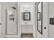 Clean bathroom with shower, vanity, and mirror, and an adjacent hall mirror at 12709 N El Frio St, El Mirage, AZ 85335