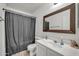Standard bathroom with a sink, toilet, and shower area with a dark shower curtain at 12709 N El Frio St, El Mirage, AZ 85335