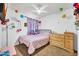 Playful bedroom with ceiling fan, toys, rainbow decor, and a dresser at 12709 N El Frio St, El Mirage, AZ 85335