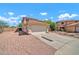 Side view of a two-story home boasting a two-car garage, desert landscaping, and a long driveway at 12709 N El Frio St, El Mirage, AZ 85335