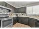 Kitchen with stainless steel appliances, dark cabinetry, and stylish backsplash at 12709 N El Frio St, El Mirage, AZ 85335