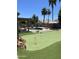 Backyard featuring a putting green, pool, and covered patio area with desert landscaping at 12753 W Vista Paseo Dr, Litchfield Park, AZ 85340