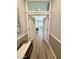 Hallway with earth-toned walls, wood-look flooring leading to a bright bedroom at 12753 W Vista Paseo Dr, Litchfield Park, AZ 85340