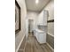 Hallway with wood floors, two-tone walls, and white cabinets with countertops provides ample storage to a nearby bathroom at 12753 W Vista Paseo Dr, Litchfield Park, AZ 85340
