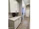 Hallway with wood-look flooring and white storage cabinets complemented by a light countertop, offering ample space at 12753 W Vista Paseo Dr, Litchfield Park, AZ 85340