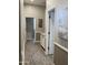 Hallway with wood floors, neutral walls, decorative artwork, and cabinets with white countertops provides ample storage at 12753 W Vista Paseo Dr, Litchfield Park, AZ 85340
