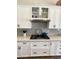 Modern kitchen with white cabinetry, designer backsplash, stainless steel hood, and gas cooktop at 12753 W Vista Paseo Dr, Litchfield Park, AZ 85340