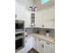 Kitchen featuring stainless steel appliances, light countertops and grey backsplash, with white cabinets at 12753 W Vista Paseo Dr, Litchfield Park, AZ 85340