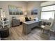 Well-lit home office with a large desk, decor art, light colored walls and wood-look flooring at 12753 W Vista Paseo Dr, Litchfield Park, AZ 85340