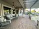 Covered patio featuring wicker furniture, ceiling fan, and brick flooring at 12753 W Vista Paseo Dr, Litchfield Park, AZ 85340