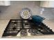 Close up of stainless steel stovetop and cookwear, with tile backsplash, and light countertops at 12753 W Vista Paseo Dr, Litchfield Park, AZ 85340