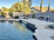 Sparkling swimming pool with waterfall feature and decorative landscaping at 12753 W Vista Paseo Dr, Litchfield Park, AZ 85340