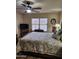 Comfortable bedroom features a ceiling fan, wood-look tile floor, and natural light from a window at 1333 E Cecil Ct, Casa Grande, AZ 85122