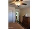 Bedroom with neutral colors, wood-look flooring, ceiling fan, and view to an ensuite bathroom at 1333 E Cecil Ct, Casa Grande, AZ 85122