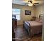 Bedroom features a bed with metal frame, wood-look flooring, ceiling fan, and plenty of natural light at 1333 E Cecil Ct, Casa Grande, AZ 85122
