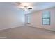 Bright bedroom with neutral carpet, ceiling fan, and two windows providing natural light at 13523 W Remuda Dr, Peoria, AZ 85383