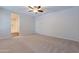 Bedroom with neutral carpet, ceiling fan, and view of ensuite bathroom at 13523 W Remuda Dr, Peoria, AZ 85383