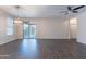 Open living room featuring wood-look tile flooring, a modern light fixture, and a sliding glass door at 13523 W Remuda Dr, Peoria, AZ 85383
