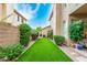 Narrow backyard space enhanced with artificial turf and lined with mature landscaping at 13566 N 93Rd Pl, Scottsdale, AZ 85260