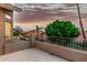 Balcony view showcasing a lush landscape, neighborhood rooftops, and a vibrant sunset sky in the background at 13566 N 93Rd Pl, Scottsdale, AZ 85260