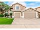 Charming two-story home featuring a well-manicured lawn and an attached three-car garage at 13566 N 93Rd Pl, Scottsdale, AZ 85260