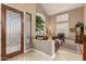 Inviting foyer with a decorative glass door, tiled floor, and a glimpse into the elegant living space at 13566 N 93Rd Pl, Scottsdale, AZ 85260