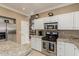 Kitchen with stainless steel appliances, granite counters, and access to dining area at 13566 N 93Rd Pl, Scottsdale, AZ 85260