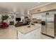 Open kitchen with stainless steel appliances, granite island, and view into living area at 13566 N 93Rd Pl, Scottsdale, AZ 85260