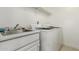 Bright laundry room features a utility sink, white cabinets, and a washer and dryer at 13566 N 93Rd Pl, Scottsdale, AZ 85260