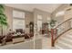 Elegant living room with high ceilings, plantation shutters, and staircase at 13566 N 93Rd Pl, Scottsdale, AZ 85260