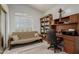 Well-lit office featuring a futon, shutters, built-in bookshelves and a desk at 13566 N 93Rd Pl, Scottsdale, AZ 85260