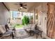 Cozy covered patio with comfortable seating, ceiling fan, and view of the fenced backyard with artificial grass at 13566 N 93Rd Pl, Scottsdale, AZ 85260