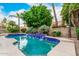 Private pool featuring tiled waterfalls and surrounding mature, colorful landscaping at 13566 N 93Rd Pl, Scottsdale, AZ 85260