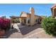 Spacious backyard features a covered patio, desert landscaping, and vibrant flowering bushes at 13584 N 102Nd Pl, Scottsdale, AZ 85260