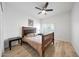 Cozy bedroom features a wood frame bed, ceiling fan, and bright window with shutter blinds at 13584 N 102Nd Pl, Scottsdale, AZ 85260