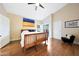 Bedroom with wood floors, ceiling fan, and large windows providing plenty of natural light at 13584 N 102Nd Pl, Scottsdale, AZ 85260