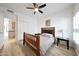 Well-lit bedroom features wood frame bed, ceiling fan, bright window, and access to closet at 13584 N 102Nd Pl, Scottsdale, AZ 85260