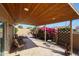 Cozy covered patio area with wood ceiling, tile flooring, outdoor seating, and lush landscaping at 13584 N 102Nd Pl, Scottsdale, AZ 85260