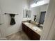 Bathroom featuring a double sink vanity with granite countertops, dark wood cabinets, and large mirror at 1492 S Pike Ln, Gilbert, AZ 85296