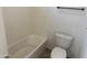 Clean and simple bathroom featuring a white bathtub, toilet, and neutral wall paint at 1492 S Pike Ln, Gilbert, AZ 85296