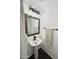 Powder room featuring a modern pedestal sink, decorative mirror, and stylish lighting fixtures at 1492 S Pike Ln, Gilbert, AZ 85296