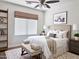 Bright bedroom featuring a plush bench, neutral colors, natural light, and ceiling fan at 1492 S Pike Ln, Gilbert, AZ 85296