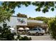 Charming coffee shop exterior with outdoor seating and a view of a modern vehicle parked nearby at 1492 S Pike Ln, Gilbert, AZ 85296