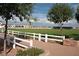 Scenic view of a community green space with a white fence, trees, and residential buildings in the background at 1492 S Pike Ln, Gilbert, AZ 85296