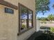 Exterior elevation showing a light stucco wall, window, address number, and green bushes at 1492 S Pike Ln, Gilbert, AZ 85296