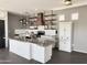 Modern kitchen featuring white cabinets, stainless steel countertops, open shelving, and a stylish wood range hood at 1492 S Pike Ln, Gilbert, AZ 85296