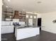 Bright kitchen with stainless steel island, white cabinetry, subway tile backsplash, and open shelving at 1492 S Pike Ln, Gilbert, AZ 85296