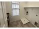 Bright laundry room with window, built-in shelf, tile flooring, and washing machine hookups at 1492 S Pike Ln, Gilbert, AZ 85296