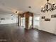 Spacious living room with wood-look tile flooring, a decorative chandelier, and sliding glass doors to the outdoor space at 1492 S Pike Ln, Gilbert, AZ 85296