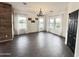 Well-lit living room boasting wood-look tile, large windows with sheer curtains, and modern chandelier at 1492 S Pike Ln, Gilbert, AZ 85296